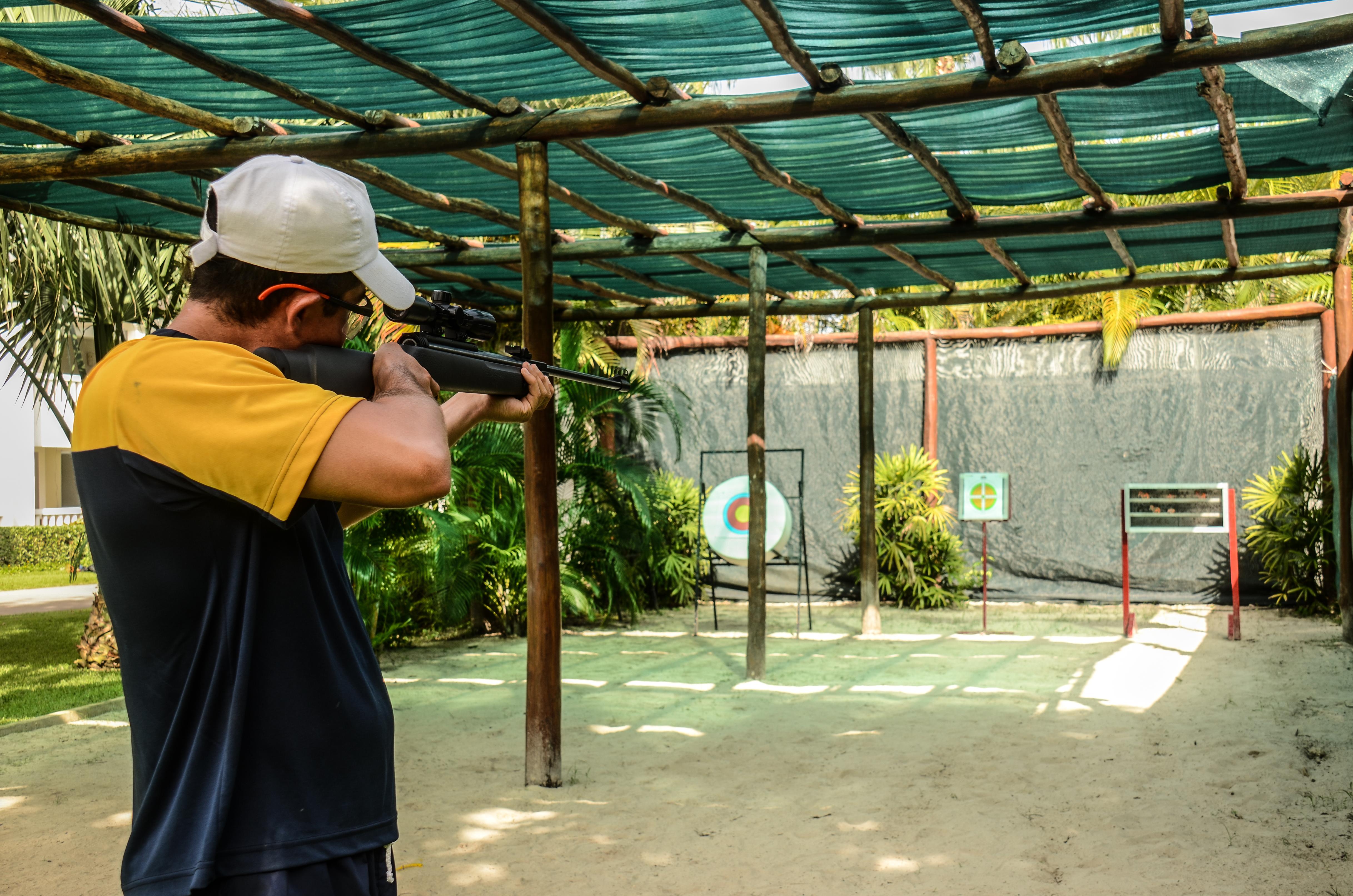Grand Sunset Princess Playa del Carmen Esterno foto A man shooting a rifle at a target